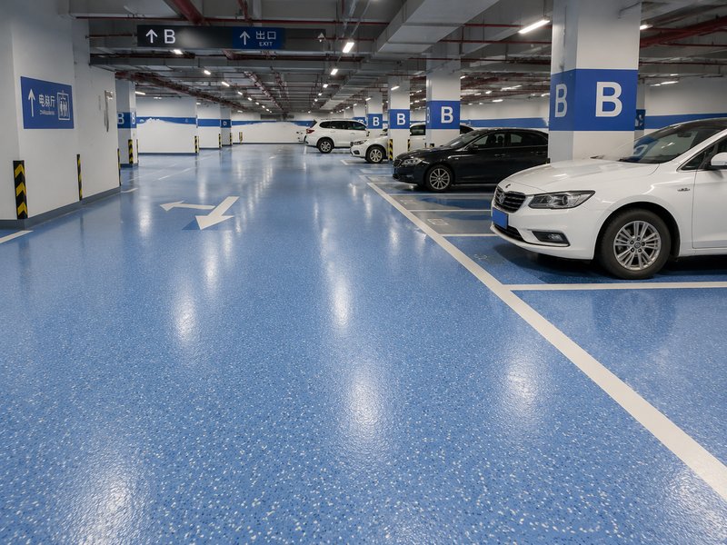 Why do high-end parking lots prefer epoxy colored sand floor coatings?